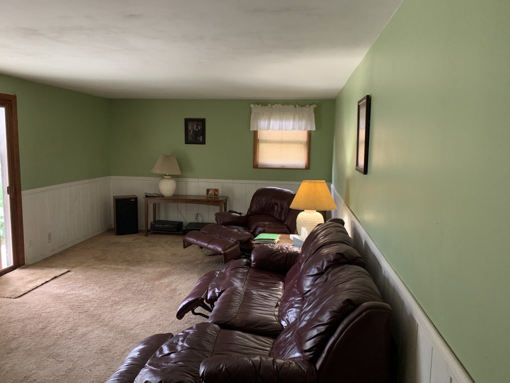 Revitalizing Neighborhoods, One House At A Time 12 A lounge area of a home featuring lime green walls and leather recliners.