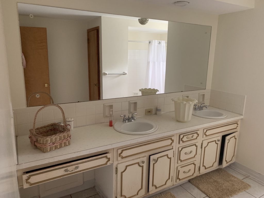 Revitalizing Neighborhoods, One House At A Time 9 A bathroom with a rectangular mirror the length of the counter.