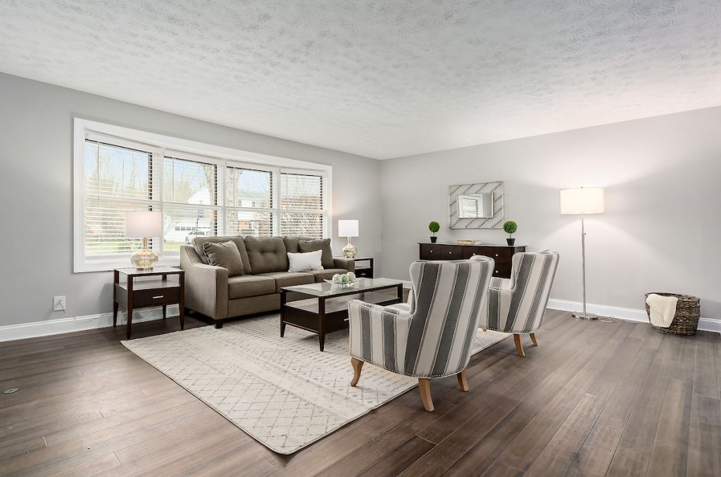 Revitalizing Neighborhoods, One House At A Time 16 A lovely living room with modern chairs, flooring, and a rug.