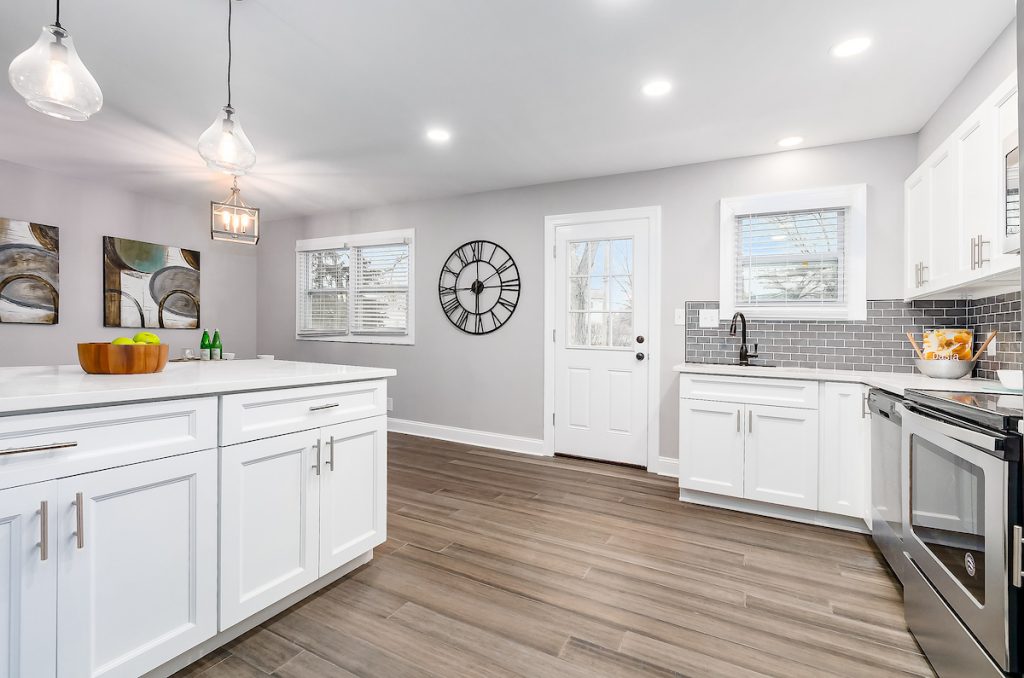 Revitalizing Neighborhoods, One House At A Time 7 A kitchen with all white cabinets.