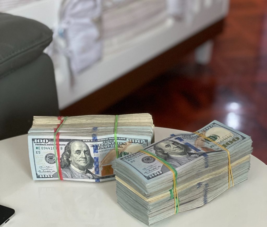 3 Myths of a "Cash for Keys" Agreement 3 Two fat stacks of one-hundred-dollar bills on a table in a house.