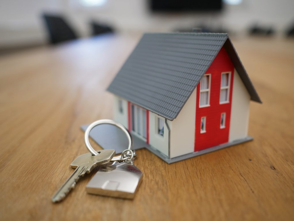 What Does a Title Company Do? 4 Miniature house with a set of keys on a wooden table.